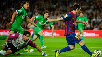 El argentino Lionel Messi del Barcelona anota un gol tras dejar atrás a la defensa y al portero del Racing de Santander.