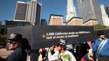 Un ataúd es cargado por manifestantes, en referencia a las personas que mueren en California cada mes por falta de acceso a cuidado sanitario.