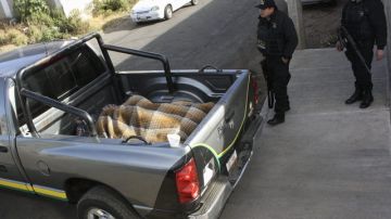 Agentes estatales resguardan los cuerpos de 13 personas asesinados en la madrugada de ayer, en el municipio de Zitácuaro, en  Michoacán.