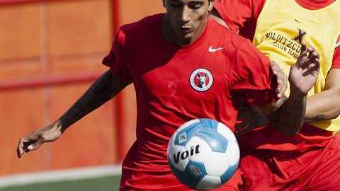 Édgar Castillo y Alan Pulido pelean el balón durante el entrenamiento del cuadros de los Xoloitzcuintles, que recibirán al Monterrey.