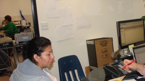 Un empleado del consulado salvadoreño ayuda a Martha Andrade procesar su reinscripción al TPS.