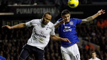 El jugador del Tottenham, Younes Kaboul(izq.), pelea el balón con el integrante del Everton,  Tim Cahill, durante el juego de ayer.