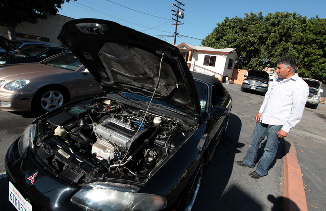 Esteban Perea, vendedor de autos en Lynwood, muestra uno de los vehículos.