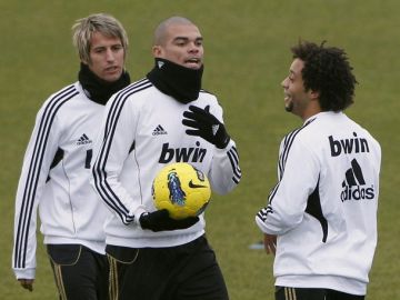 El defensa  del Real Madrid Marcelo Vieira (der.) con  Pepe y Fabio Coentrao  durante el entrenamiento del equipo de ayer.