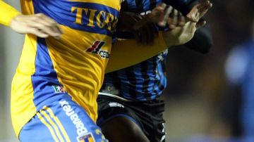 Juninho (izq.), de Tigres, controla el balón ante la marca de un jugador de Gallos Blancos, en duelo celebrado en el llamado 'Volcán'.