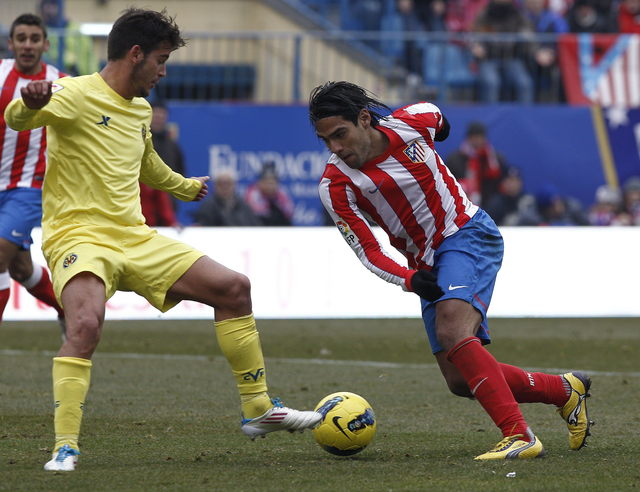 Radamel Falcao (der.) maniobra  ante  Joan Oriol, del Villarreal. El ariete colombiano anotó dos goles en la victoria de los 'colchoneros'.