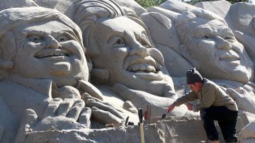 Un escultor da  toques finales a figuras de los candidatos -Gingrich (izq.), Huntsman y Perry- en el lugar del debate de hoy en  Myrtle Beach.