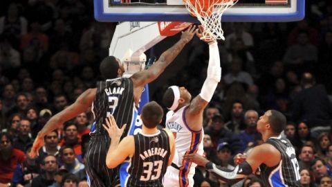 El alero Carmelo Anthony (2d), de los New York Knicks, entra a canasta delante de Earl Clark (i), Ryan Anderson (2i) y Dwight Howard (d), de los Orlando Magic.