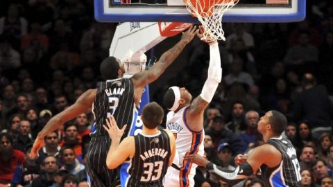 El alero Carmelo Anthony (2d), de los New York Knicks, entra a canasta delante de Earl Clark (i), Ryan Anderson (2i) y Dwight Howard (d), de los Orlando Magic.