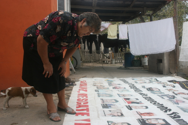 Trinidad Cantú, quien perdió un hijo en la mina, observa una manta con los nombres de los trabajadores fallecidos.