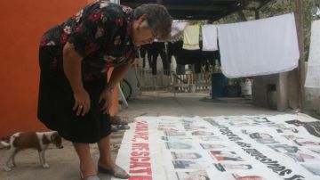 Trinidad Cantú, quien perdió un hijo en la mina, observa una manta con los nombres de los trabajadores fallecidos.