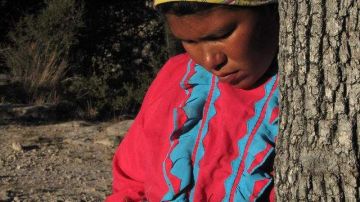 Una joven tarahumara trabaja una manualidad.
