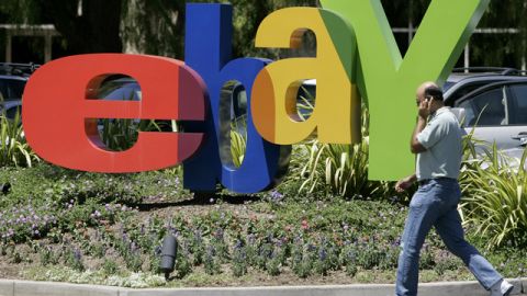 Un trabajador de eBay pasa al lado del nombre de la compañía, en su oficina central, en San José, California.