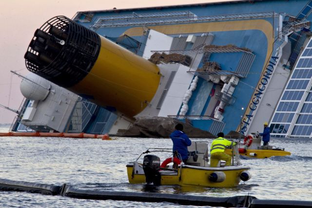 Técnicos de medio ambiente instalan barreras flotantes alrededor del "Costa Concordia" luego de que gobierno italiano aseguró que ya se produjo "daño ambiental" en el fondo marino.