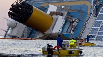 Técnicos de medio ambiente instalan barreras flotantes alrededor del "Costa Concordia" luego de que gobierno italiano aseguró que ya se produjo "daño ambiental" en el fondo marino.
