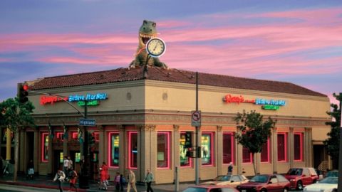 La fachada del museo se distingue por sus luces de neón y dinosaurio en el techo.