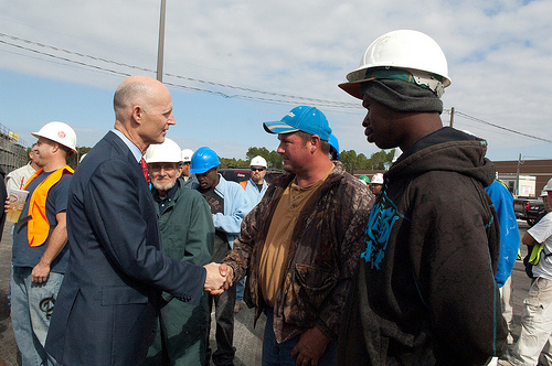 El gobernador Rick Scott saluda empleados en el sector de construcción en Jacksonville.