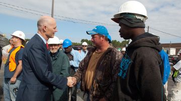 El gobernador Rick Scott saluda empleados en el sector de construcción en Jacksonville.