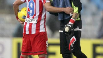 El delantero colombiano Radamel Falcao, del Atlético de Madrid (i), consuela al portero chileno Claudio Bravo, de la Real Sociedad, al final del partido que ganaron los capitalinos ayer en el estadio de Anoeta.