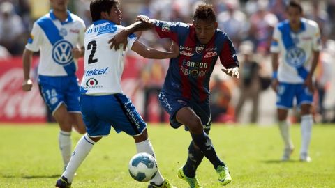 Aldo Polo, de Puebla (2), no  puede detener la acción  de Michael Arroyo, del Atlante. Los Potros ganaron  su segundo partido de visita.