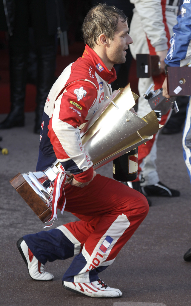 Loeb carga con su trofeo.