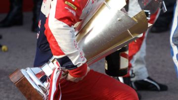 Loeb carga con su trofeo.