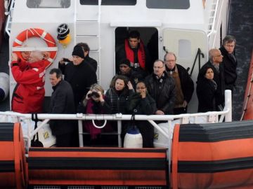 Varios familiares de víctimas navegan en un barco de la guarda costera junto al crucero Costa Concordia.