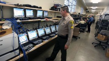 El sargento Antonio León,  del LASD,  muestra las computadoras que serán instaladas en las diversas patrullas.
