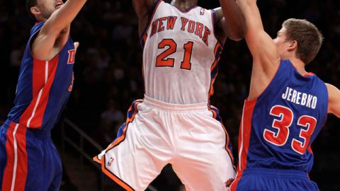 Iman Shumpert (centro) dispara a la canasta pese al acoso de los defensas de los Pistones, Austin Daye (izq.) y  Jonas Jerebko.