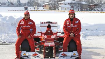 Felipe Massa (izq.) y Fernando Alonso posan con el monoplaza que Ferrari estrenará el martes en Jerez de la Frontera.