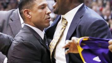 El entrenador de los Lakers Mike Brown (derecha) es sacado de la cancha por miembros de seguridad en el partido contra los Jazz de Utah, el pasado sábado.