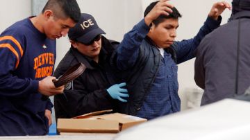 Agentes del ICE custodian a inmigrantes.