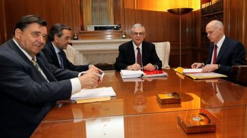 El primer ministro griego Lukas Papademos (2-der.) preside la reunión con los líderes de los tres partidos principales griegos.