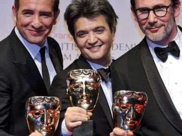 El actor francés Jean Dujardin (i), el productor Thomas Langmann (c) y el director Michel Hazanavicius (d) posan con el premio a mejor película.