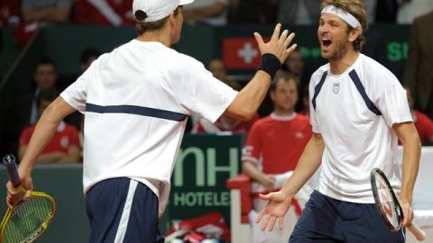 Mardy Fish (der.) y Mike Bryan, de Estados Unidos, celebran luego de dar cuenta de Roger Federer y compañía, ayer, en su propia casa.