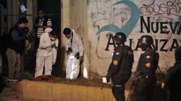 Peritos reúnen evidencias en la zona donde tres hombres, que estaban frente a una vivienda, fueron asesinados en Monterrey.