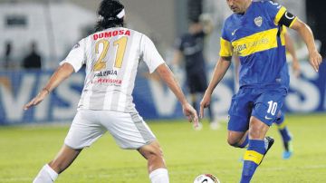 Dario Figueroa (21), del Zamora, intenta detener el avance de Juan Roman Riquelme, del Boca, ayer, en el partido de la Libertadores.