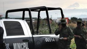 Oficiales investigan la escena del hallazgo de los cuerpos.