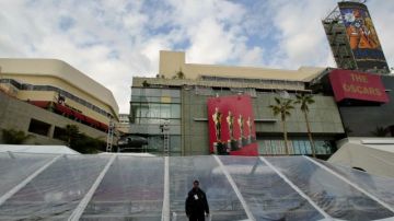 Un guardia cuida el área donde se extenderá la alfombra roja de los Premios Oscar frente al Teatro Kodak.