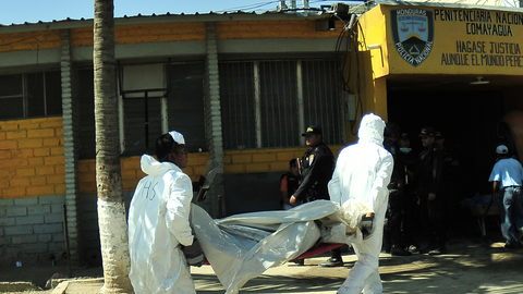 Empleados del servicio forense trasladan los cádaveres de las víctimas del incendio en la Granja Penal de Comayagua. Gustavo Amador