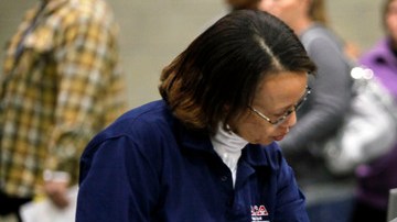 Un hombre recibe asistencia de una empleada de NACA para llenar los diversos formularios requeridos para iniciar el proceso.