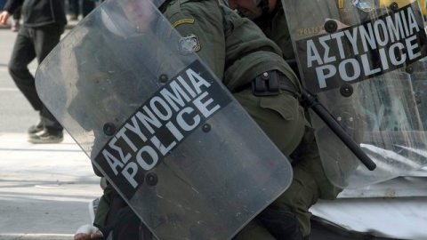 Policías antidisturbios inmovilizan a un estudiante durante la manifestación contra los planes de austeridad.