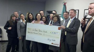 Representantes de La Raza Galería Posada, muestran el cheque de 25,000 dólares que recibieron del alcalde de Sacramento Kevin Johnson y del Banco Wells Fargo.