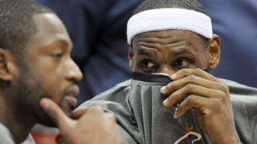 El jugador LeBron James (d) de los Heat de Miami habla con su compañero Dwyane Wade.