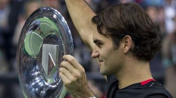 Federer alza su primer trofeo del año y saluda a sus seguidores.