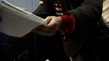 Vettel firma autógrafos antes de abordar su bólido.