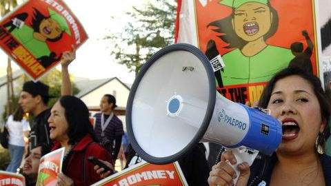 La presidente de la Coalición de Arizona por el Dream Act, Dulce Matuz, hablaba con sus seguidores a través del megáfono en una manifestación días atrás. En el fondo, la activista, Dolores Huerta.