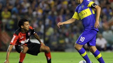 Cuando Boca sufría  ante Newell's, Juan Román Riquelme (10) borró las dudas con un gol de tiro libre. Aquí  supera a   Leonel Vangioni.