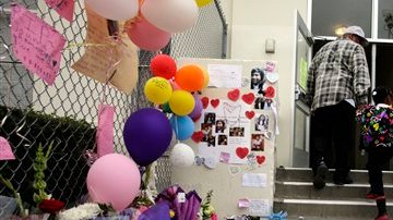 Estudiantes y padres miran el altar colocado en memoria de Joanna Ramos en la primaria de Long Beach.