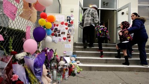 Estudiantes y padres miran el altar colocado en memoria de Joanna Ramos en la primaria de Long Beach.